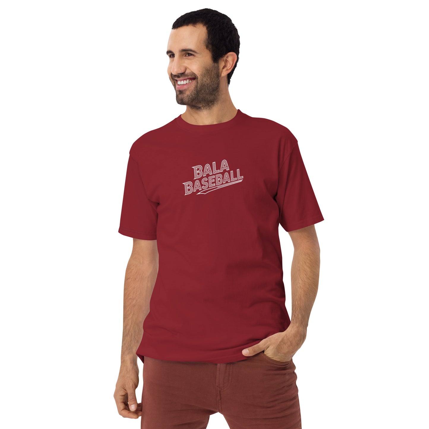 Man wearing a red "Bala Baseball" t-shirt, smiling and posing with one hand in pocket.